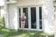 A girl with a backpack standing in front of a house.