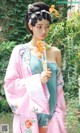 a woman in a pink and blue hanbob holding a flower