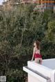 A woman in a red bikini standing on a balcony.