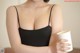 A woman in a black bra holding a cup of coffee.