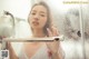 A woman taking a shower in a glass shower stall.